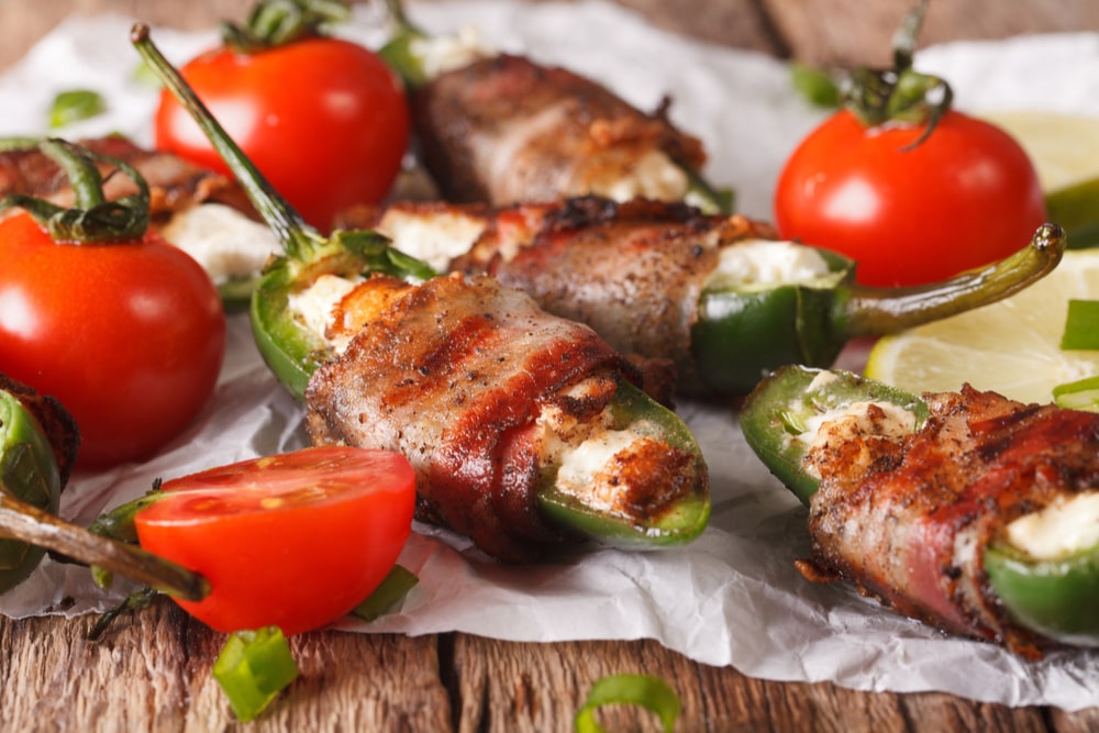 Jalapeno poppers filled with chive cream cheese and wrapped with bacon